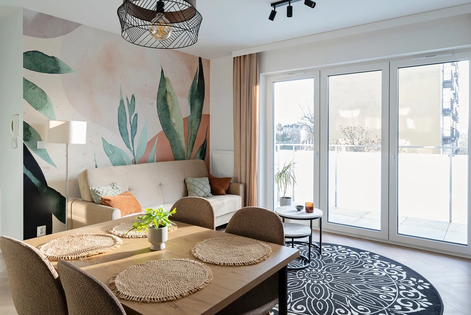 Espace de travail moderne avec bureau blanc, feuilles de papier colorées rose et vert menthe disposées en composition géométrique, stylo turquoise, clavier d'ordinateur blanc et feuilles de palmier dorées décorative